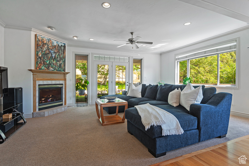 Living room with ceiling fan, ornamental molding, and a fireplace