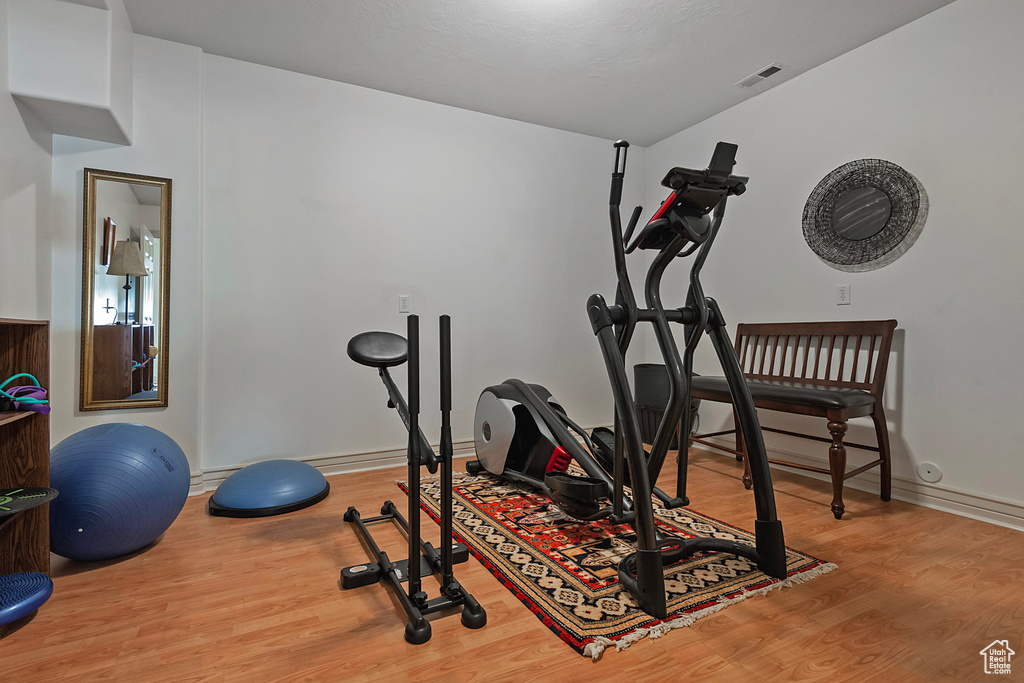 Workout area with hardwood / wood-style floors