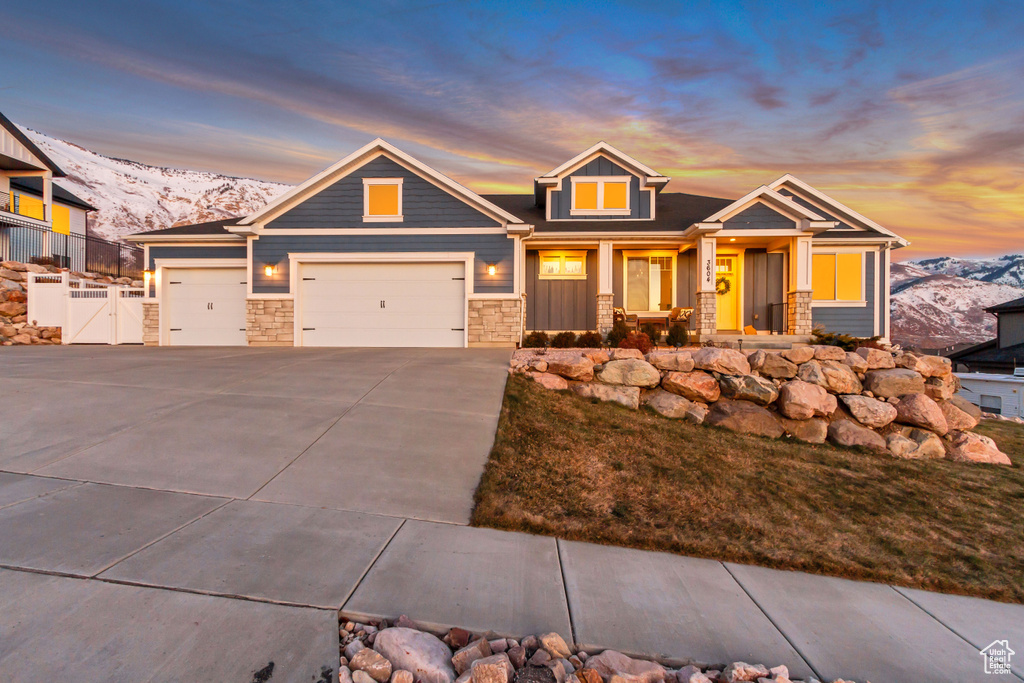 Craftsman-style house with a porch, a garage, and a mountain view
