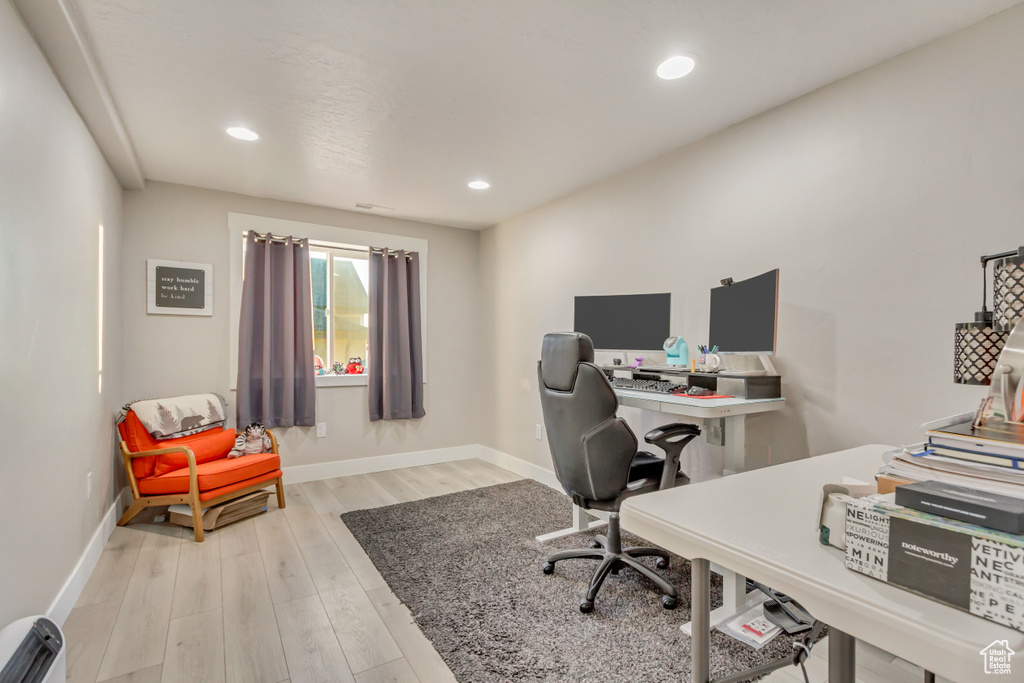 Home office with a baseboard heating unit and light wood-type flooring