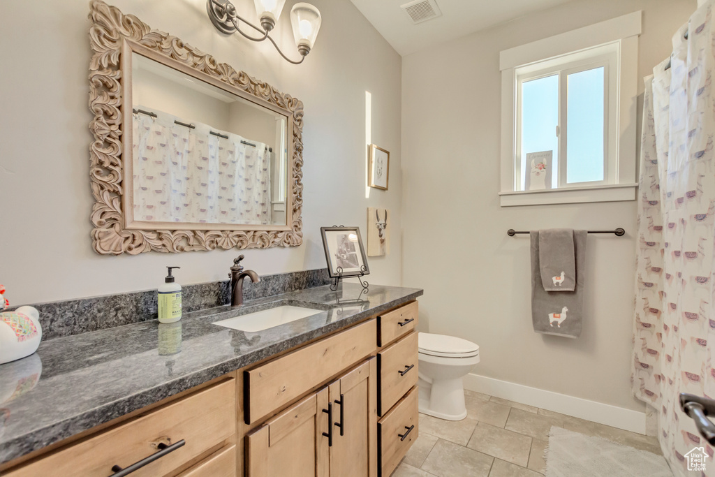 Bathroom with vanity, tile patterned flooring, and toilet