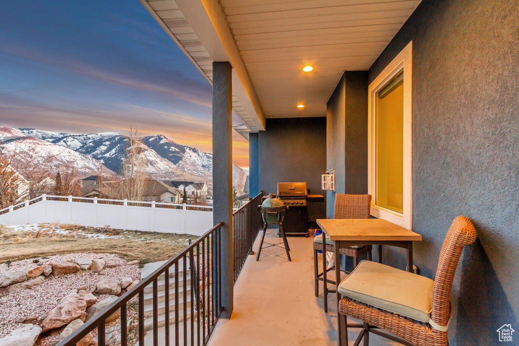 Snow covered back of property with a mountain view and grilling area