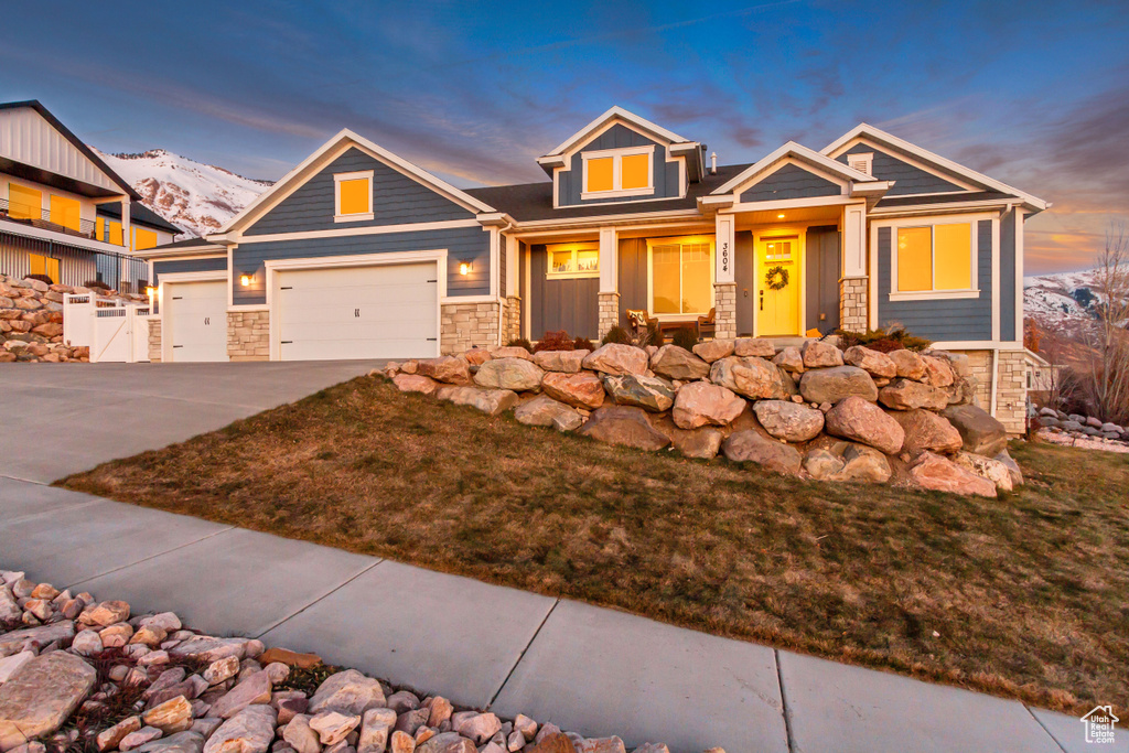 Craftsman house with a mountain view, a garage, and a lawn
