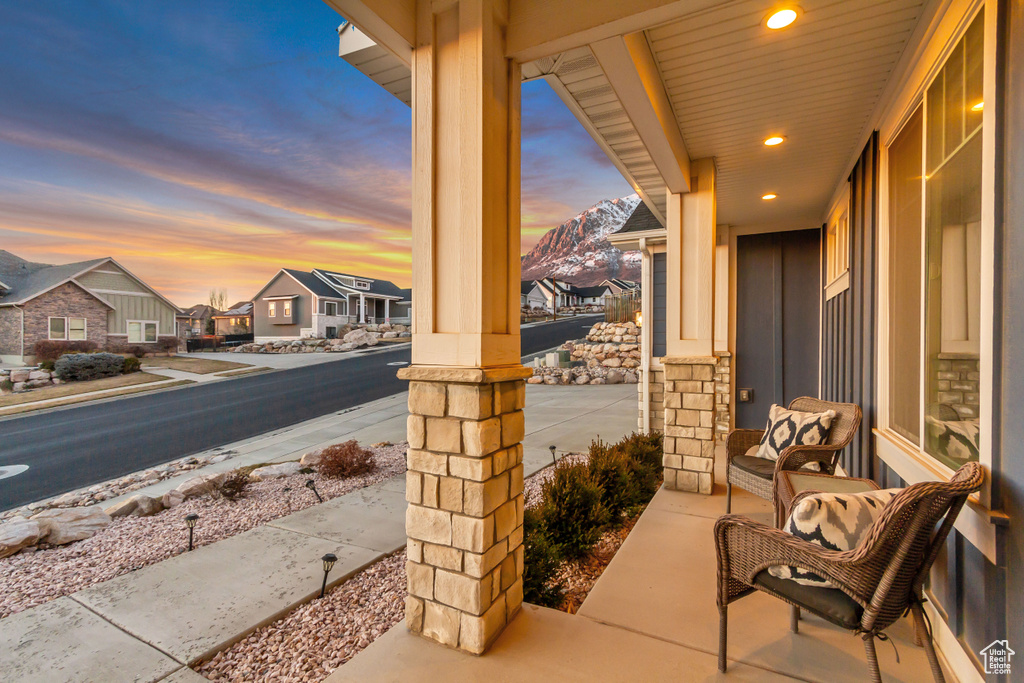 Patio terrace at dusk with a mountain view and covered porch