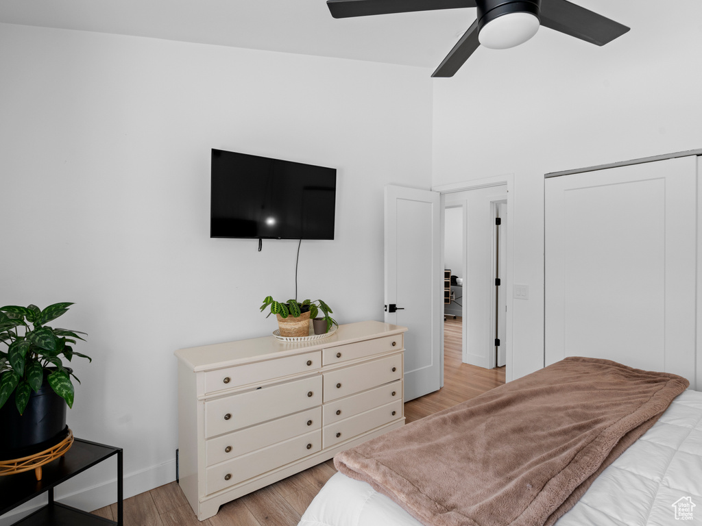 Bedroom with light hardwood / wood-style flooring, a closet, and ceiling fan