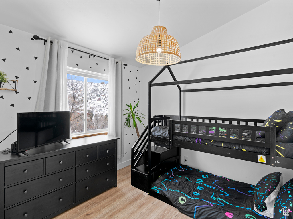 Bedroom with lofted ceiling and light hardwood / wood-style flooring