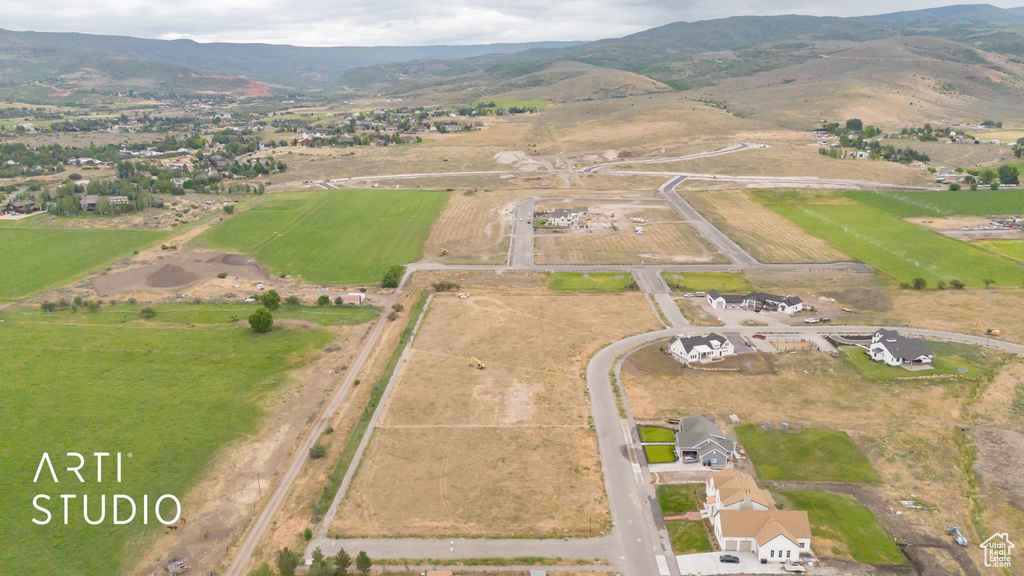 Aerial view of property and surrounding area featuring rural landscape and a mountain backdrop