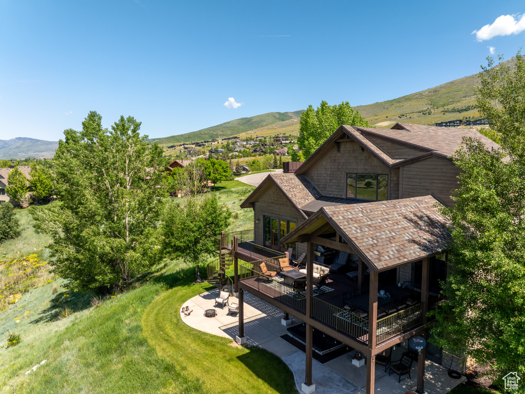 Aerial view of property and surrounding area featuring a mountain backdrop
