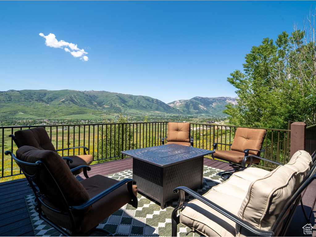 Wooden deck featuring a mountain view and an outdoor hangout area