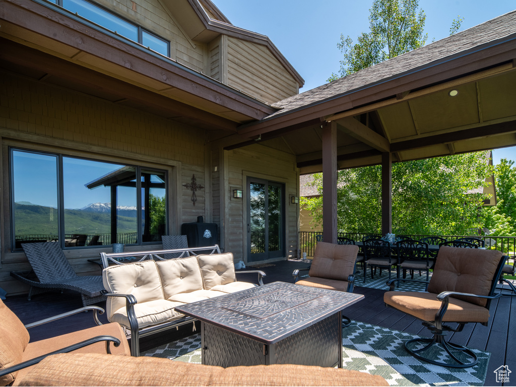 Wooden deck with outdoor lounge area, outdoor dining area, and a mountain view