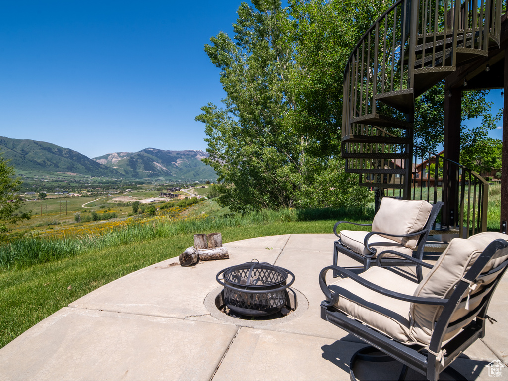 View of patio featuring stairway, a fire pit, and a mountain view