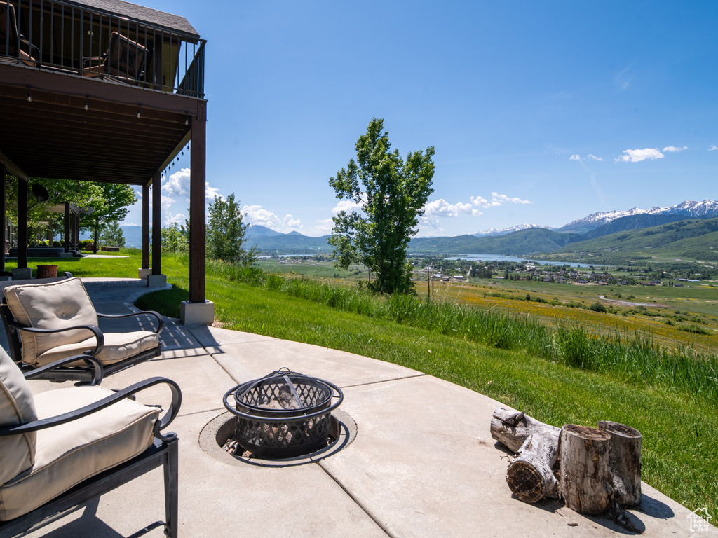 View of patio with an outdoor fire pit, a mountain view, a view of rural / pastoral area, and a balcony