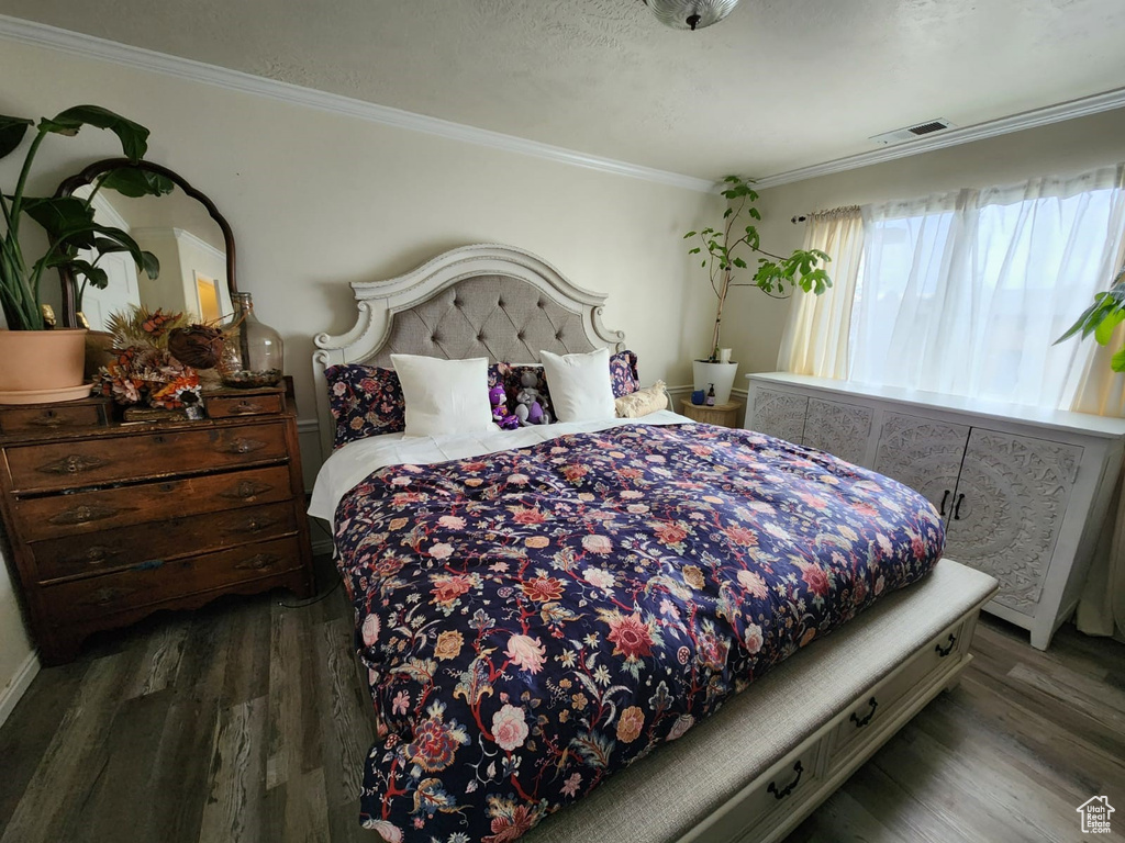 Bedroom featuring wood finished floors and ornamental molding