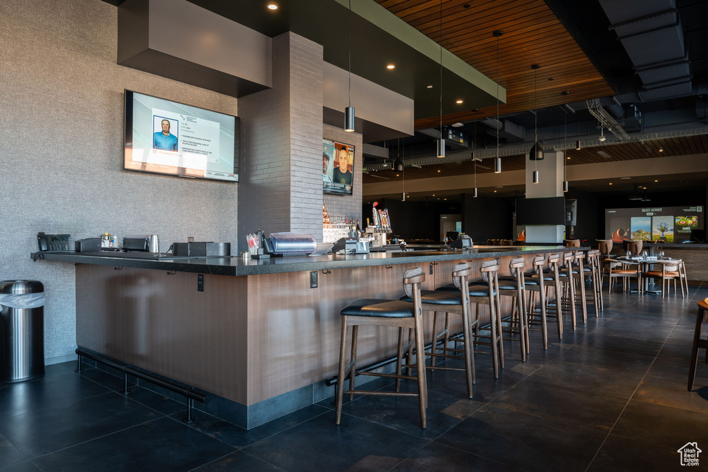 Kitchen with a breakfast bar, kitchen peninsula, and wood ceiling