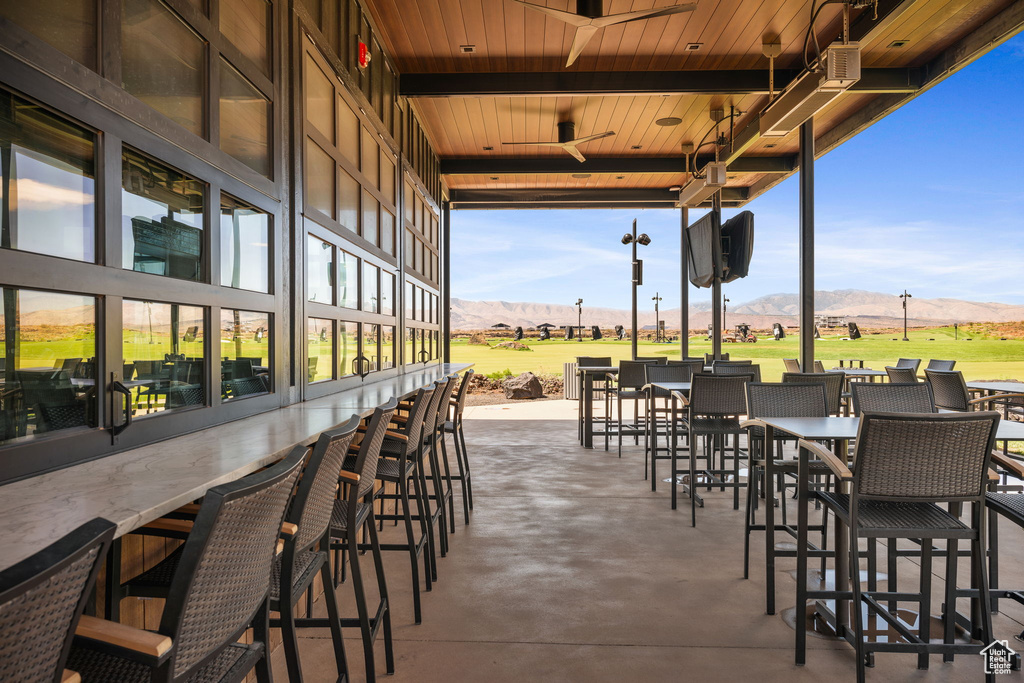 View of patio / terrace featuring a mountain view, a bar, and ceiling fan