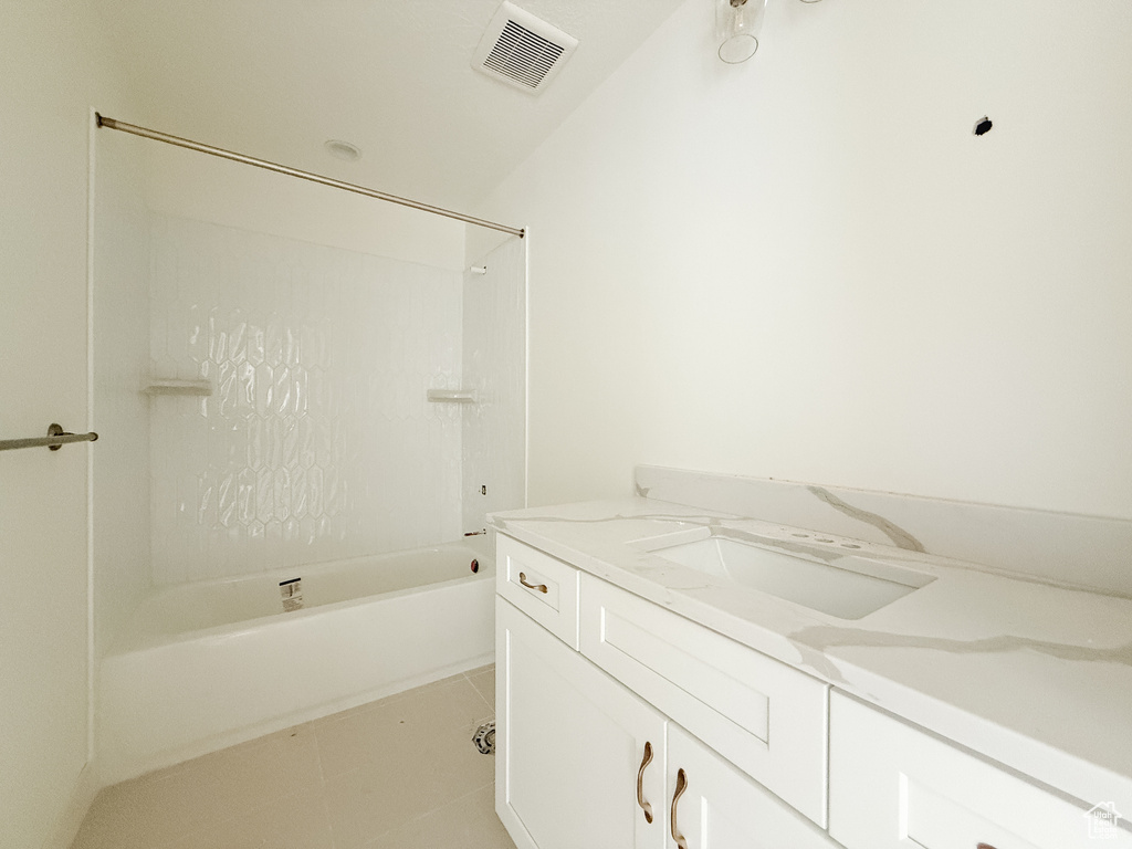 Bathroom with vanity, bathtub / shower combination, and tile patterned flooring