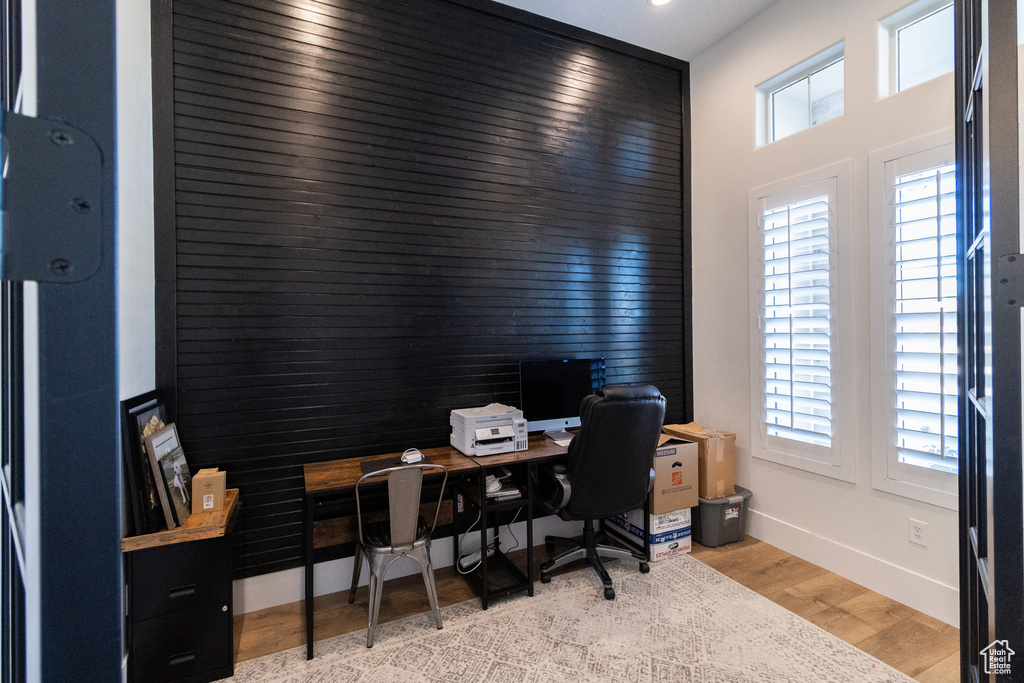 Office space with a wealth of natural light and light hardwood / wood-style flooring