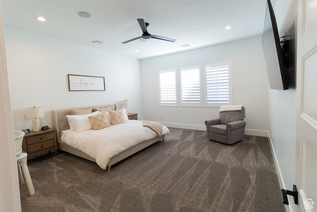 Bedroom with ceiling fan and dark colored carpet