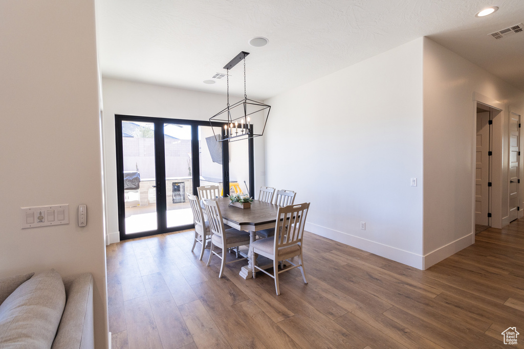 Dining area featuring french doors, dark hardwood / wood-style floors, and a notable chandelier