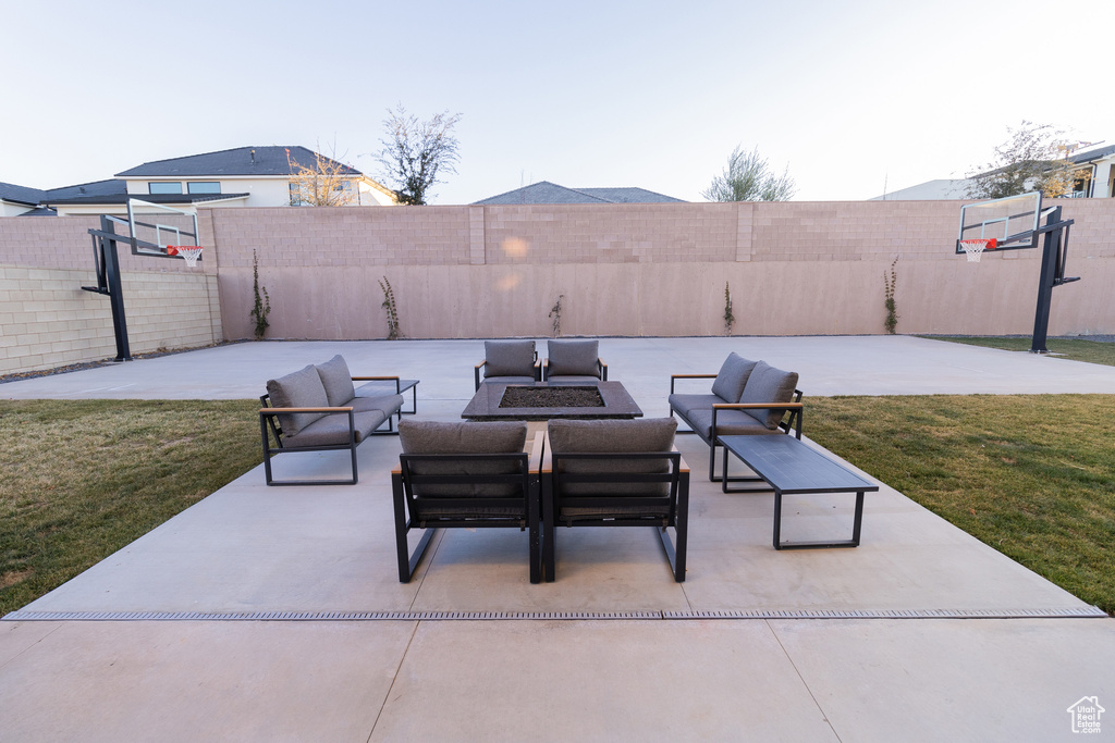 View of patio with an outdoor living space and basketball hoop