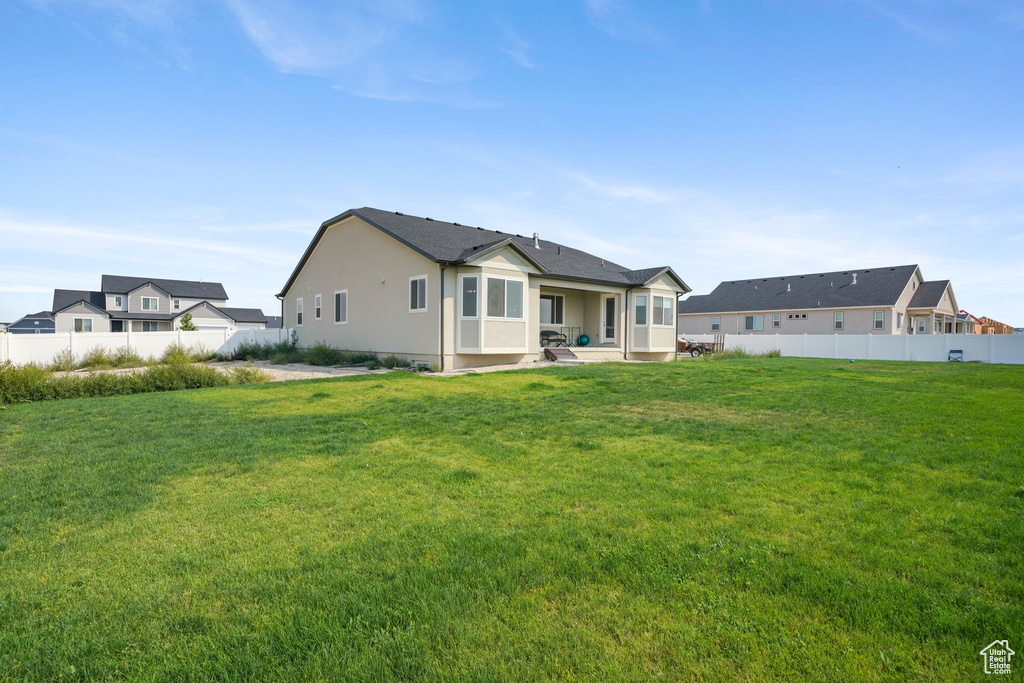 Rear view of property with a yard