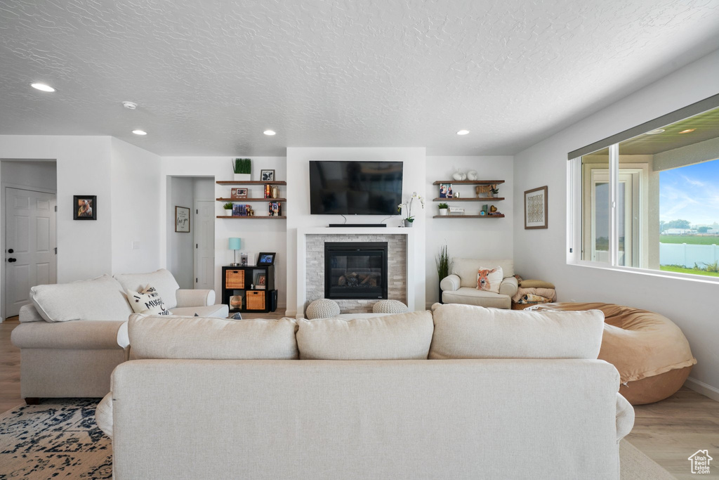 Living room featuring light hardwood / wood-style flooring and a textured ceiling