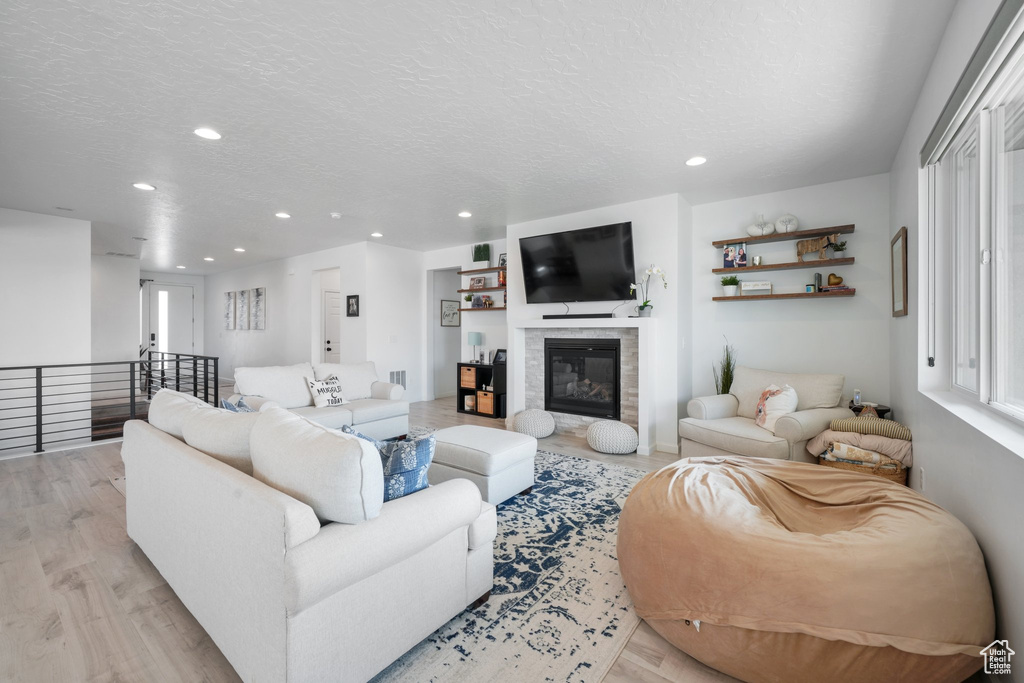 Living room with a textured ceiling and light hardwood / wood-style floors