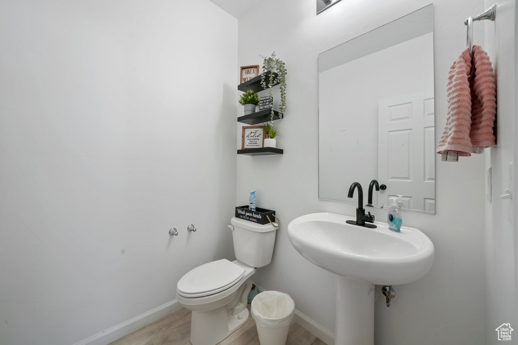 Bathroom featuring wood-type flooring and toilet