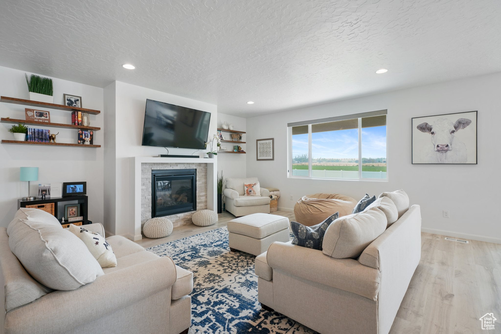 Living room with light hardwood / wood-style floors and a textured ceiling