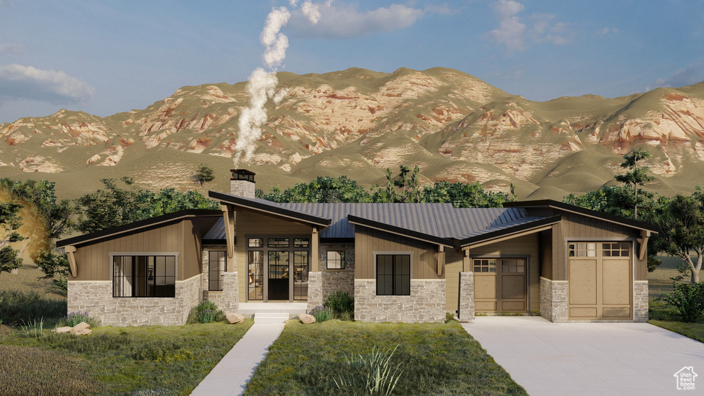 View of front of property with a garage, a mountain view, and a front lawn