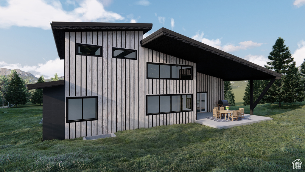 View of side of home featuring a mountain view, a yard, and a patio area