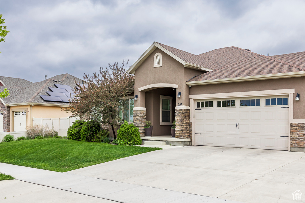 View of front of house with stone siding, stucco siding, an attached garage, driveway, and a shingled roof