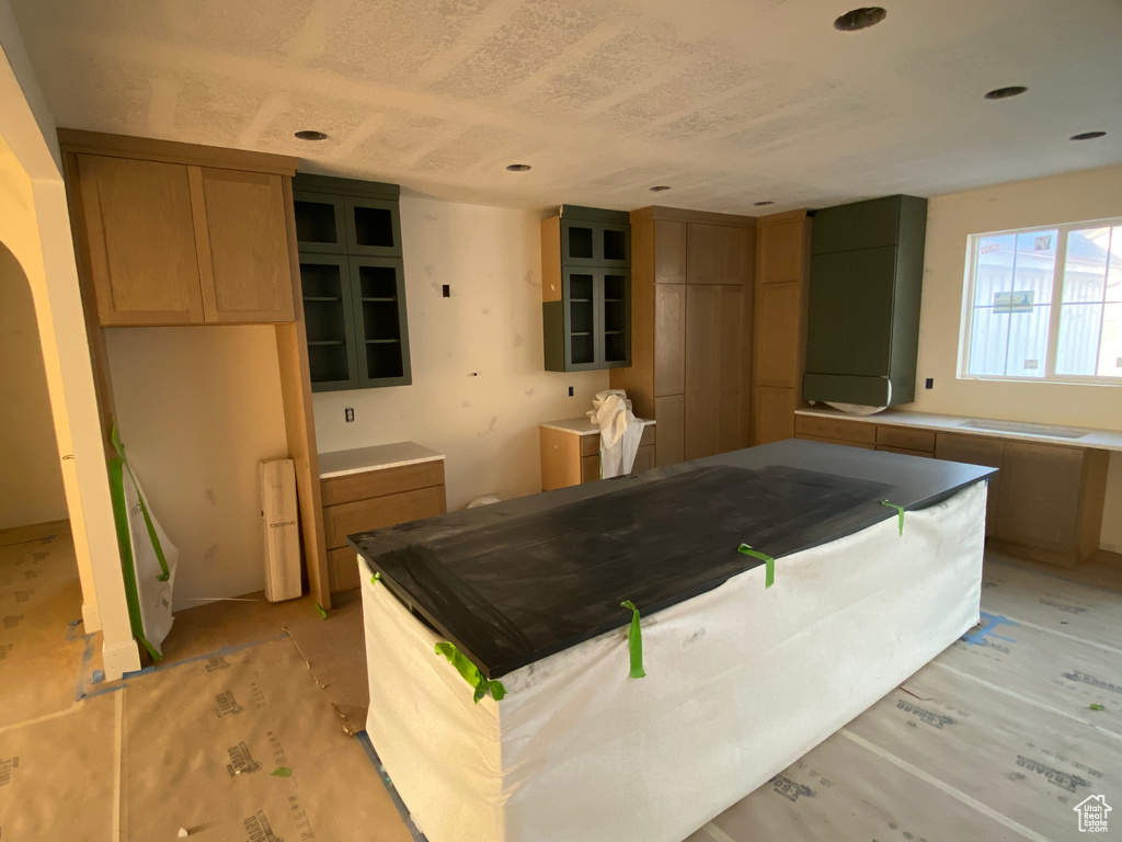 Kitchen with glass insert cabinets, a center island, and recessed lighting