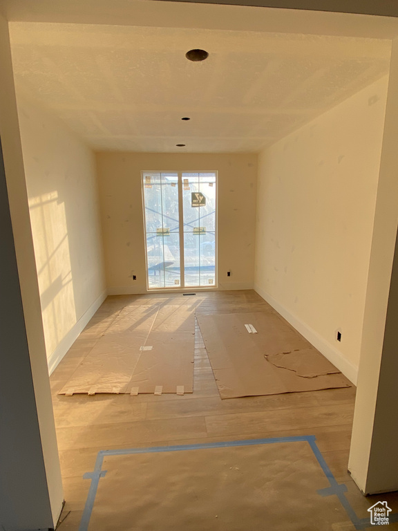 Empty room with baseboards and light wood-style flooring