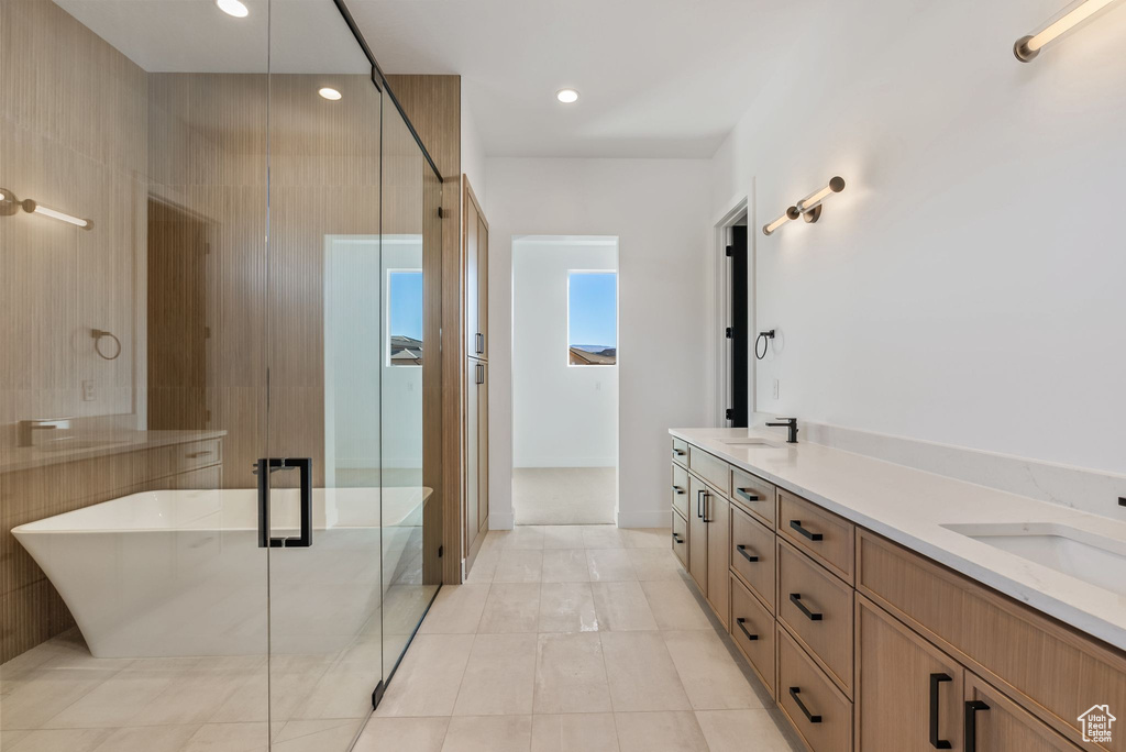 Bathroom featuring vanity, tile patterned flooring, and shower with separate bathtub