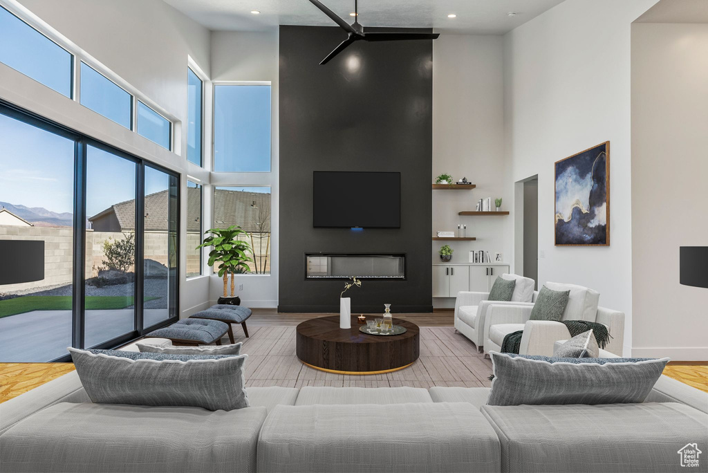 Living room featuring a large fireplace, hardwood / wood-style floors, and a high ceiling