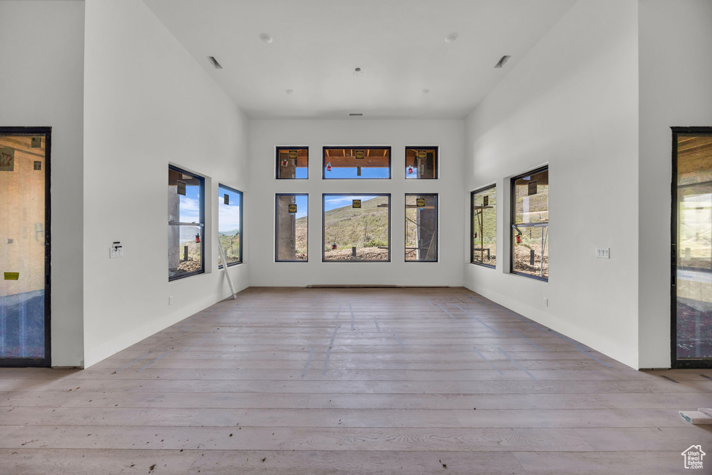 Unfurnished living room with a high ceiling and hardwood / wood-style flooring