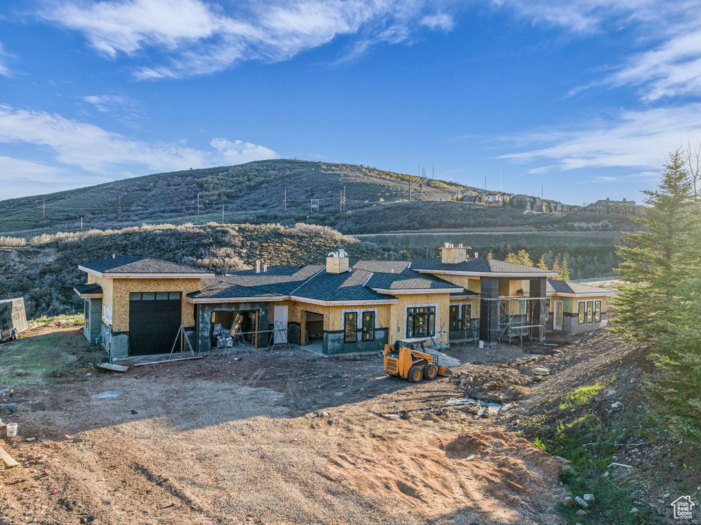 Back of property with a mountain view, a chimney, and french doors