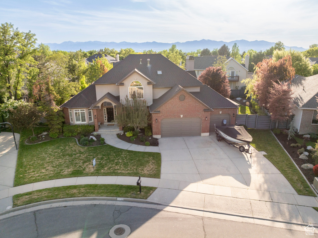 Traditional-style home featuring concrete driveway, brick siding, an attached garage, and a mountain view