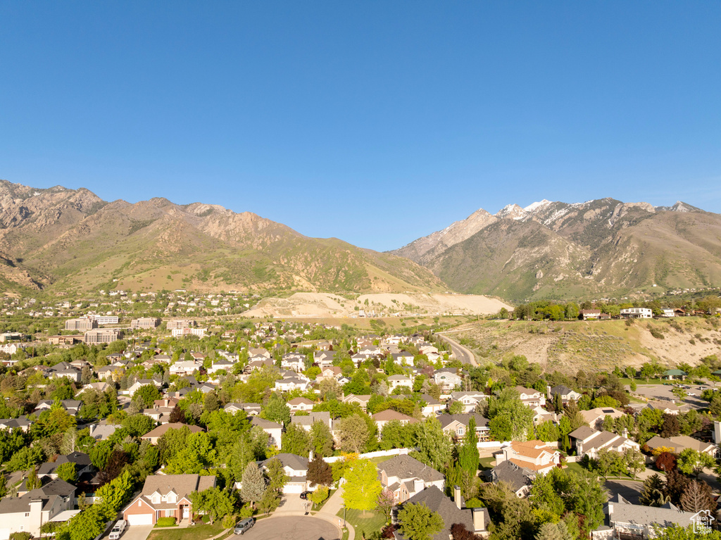 Aerial view of property and surrounding area with a mountain backdrop and nearby suburban area