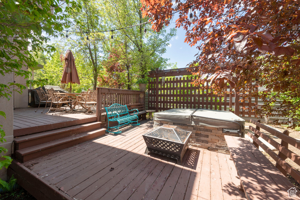 Wooden deck with a fire pit and outdoor dining space