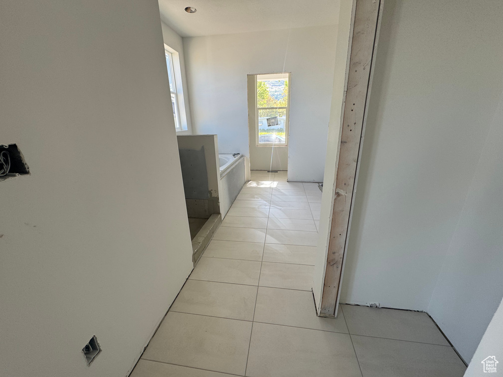 Corridor with light tile patterned flooring