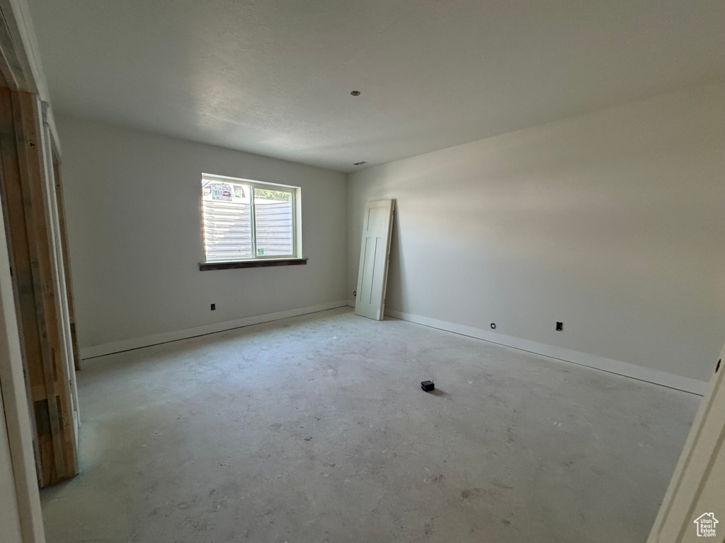 Unfurnished room with concrete floors and baseboards