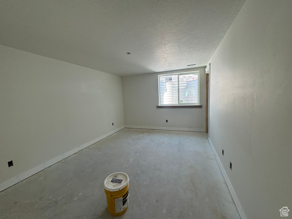 Empty room with concrete floors and a textured ceiling