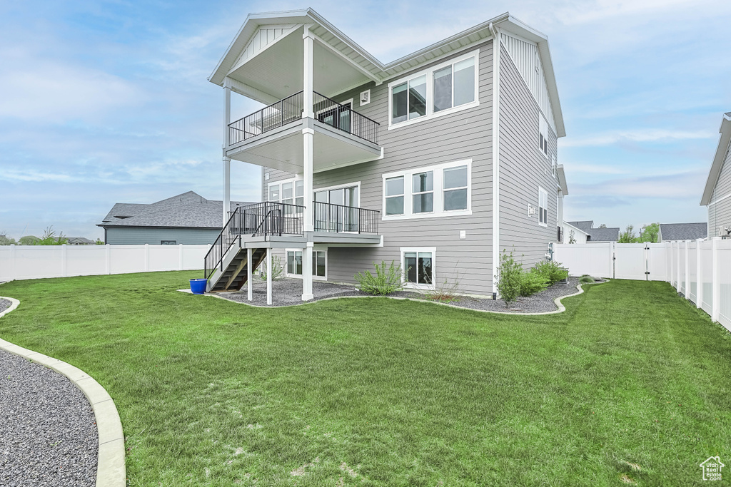 Rear view of house with a balcony, stairway, a gate, and a deck