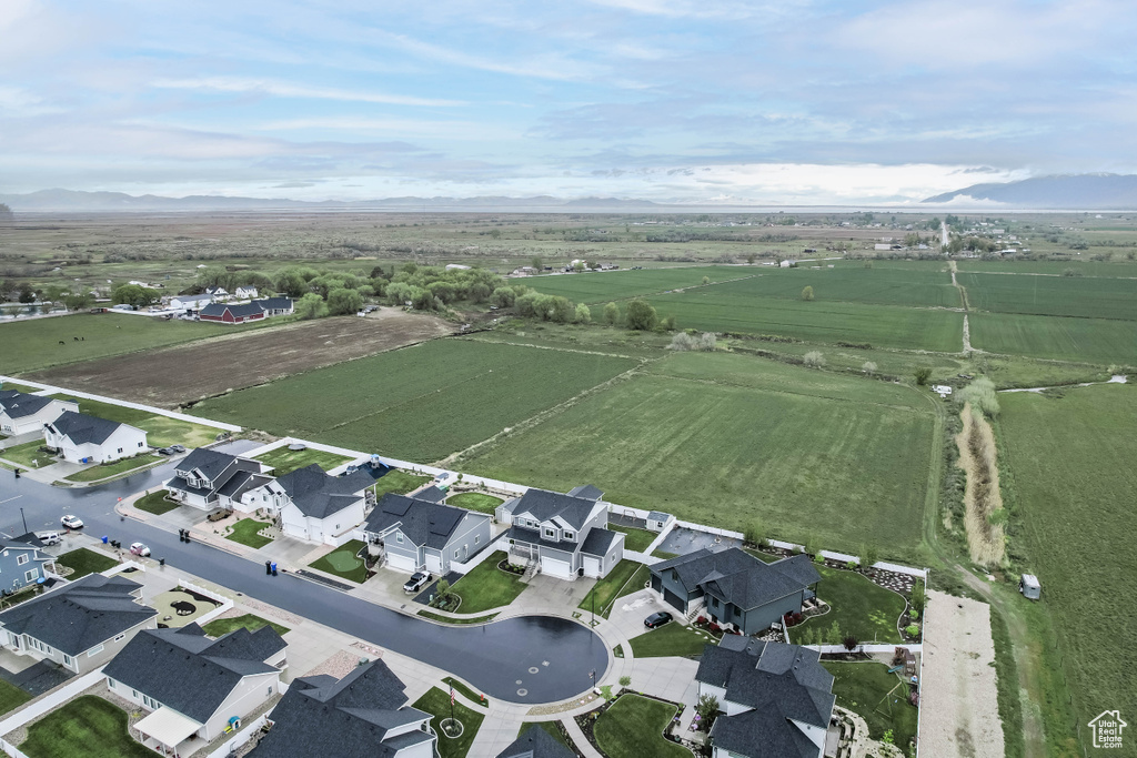 Aerial view of property and surrounding area featuring rural landscape and a mountainous background