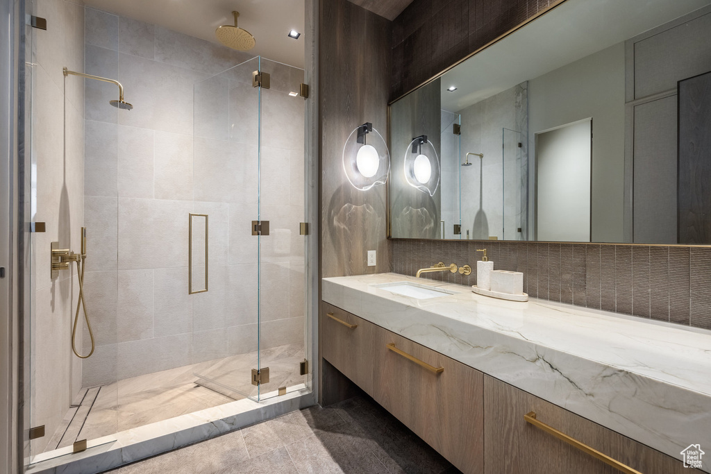 Full bathroom with a stall shower, vanity, and backsplash