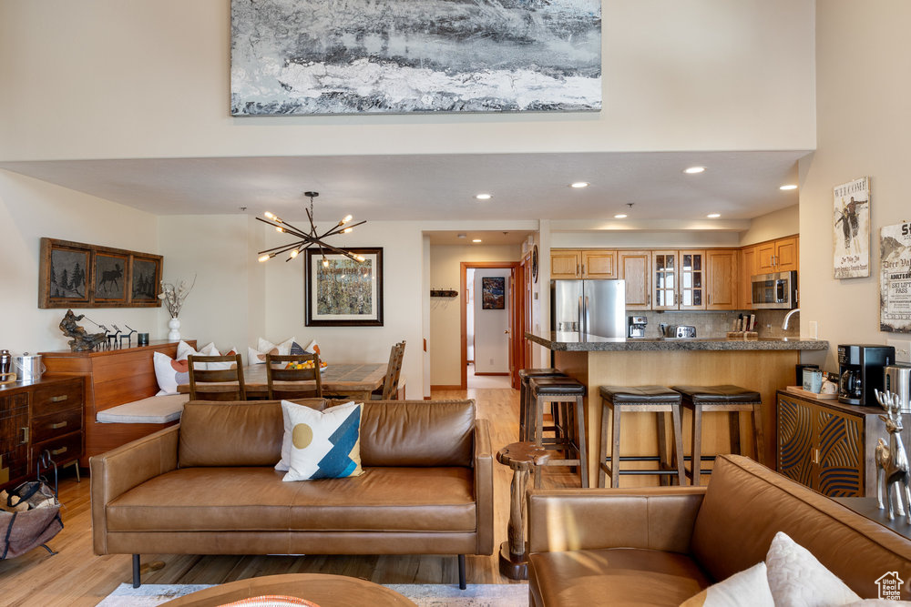 Living room with a notable chandelier and light hardwood / wood-style floors