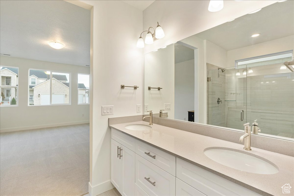 Bathroom featuring vanity and a shower with shower door