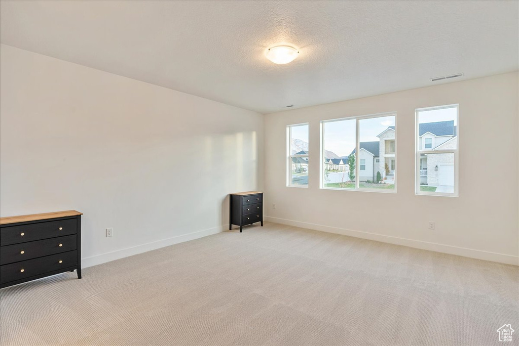 Carpeted empty room featuring a textured ceiling